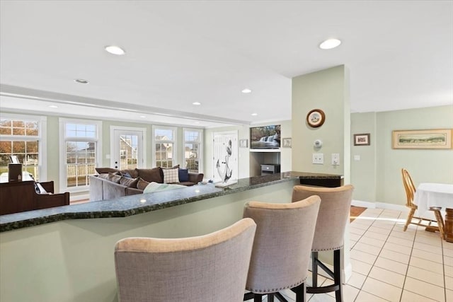 99 Ashburton Ave, Marshfield, MA 02050 - kitchen featuring a kitchen bar, light tile patterned floors, recessed lighting, baseboards, and open floor plan
