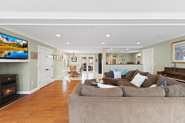 living room with a fireplace, ornamental molding, and light hardwood / wood-style flooring