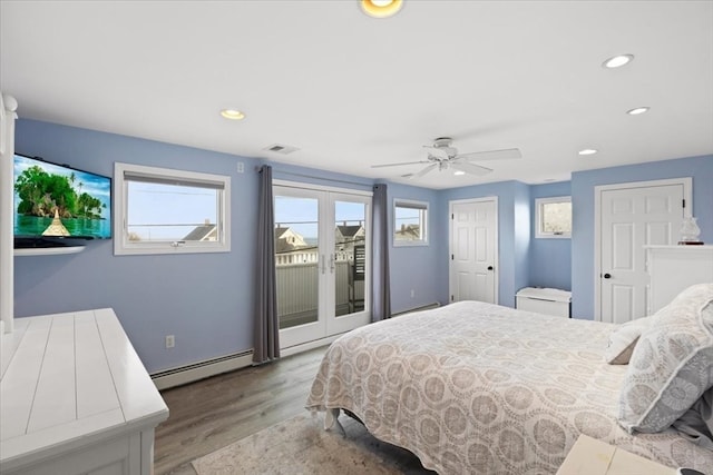 bedroom featuring a baseboard heating unit, access to outside, french doors, ceiling fan, and light wood-type flooring