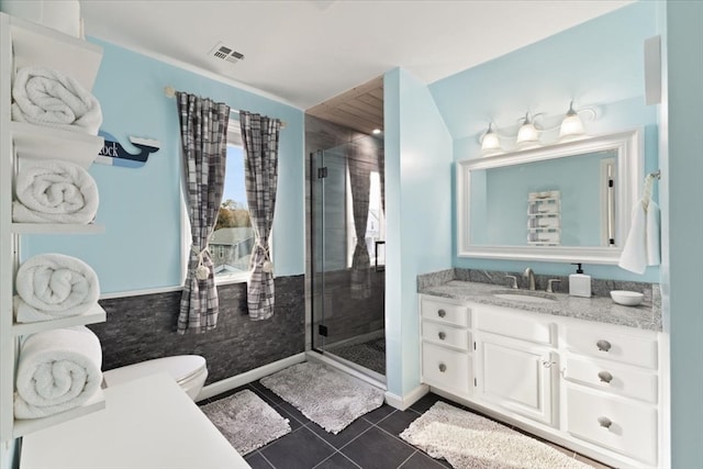 bathroom with vanity, a shower with door, tile patterned flooring, and toilet