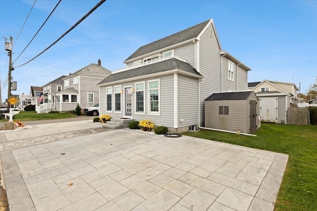 rear view of house featuring a shed, a patio, and a yard