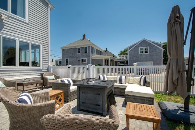 view of patio with an outdoor living space with a fire pit