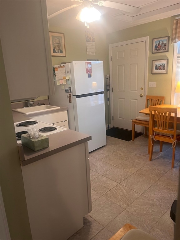 kitchen with light tile patterned floors, white appliances, ceiling fan, and sink