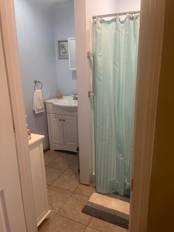 bathroom featuring vanity, tile patterned floors, and curtained shower