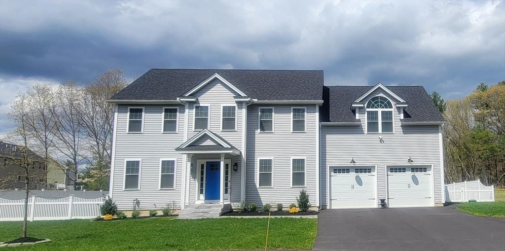 view of front of property with a garage and a front lawn