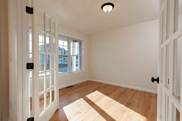 empty room featuring light hardwood / wood-style flooring and french doors