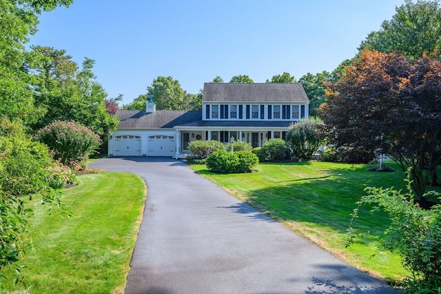 colonial inspired home with a garage and a front lawn