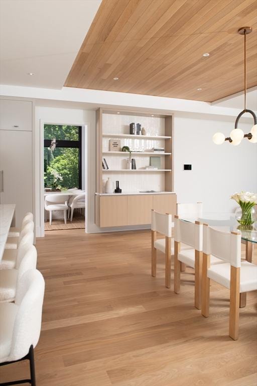 interior space featuring pendant lighting, wooden ceiling, a notable chandelier, and light wood-style flooring