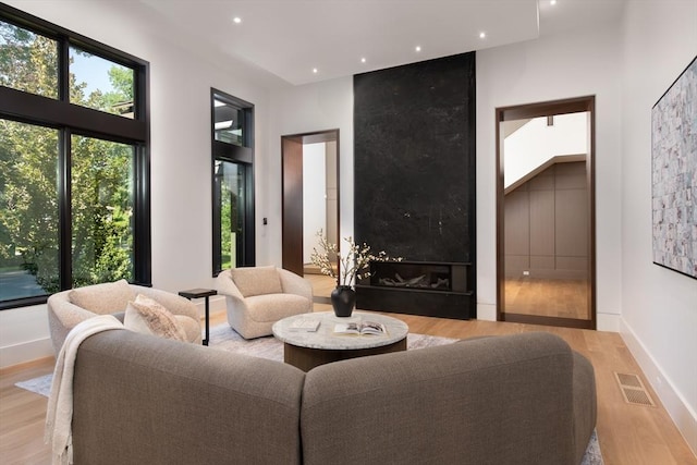 living area featuring baseboards, wood finished floors, visible vents, and recessed lighting