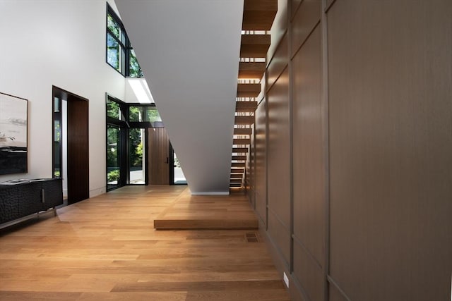 hallway featuring a high ceiling and light wood-style flooring