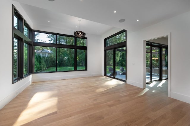 empty room with light wood finished floors, baseboards, and recessed lighting