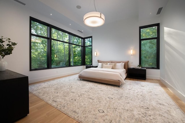 bedroom with visible vents, multiple windows, and wood finished floors