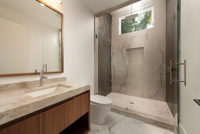 full bath with toilet, marble finish floor, a marble finish shower, and vanity