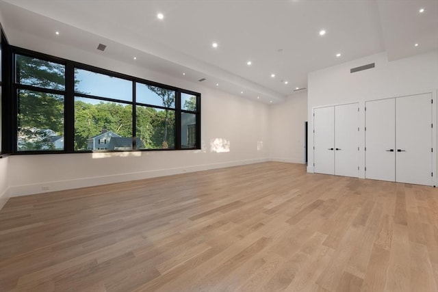 empty room featuring baseboards, light wood-type flooring, visible vents, and recessed lighting