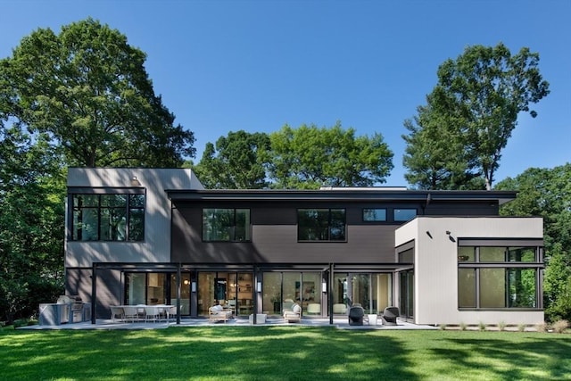 back of property featuring a patio and a lawn