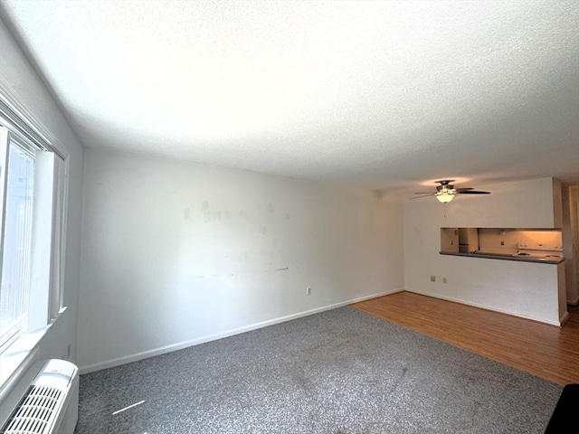101 Fletcher Unit K, Brewster, MA 02631 - unfurnished living room with healthy amount of natural light, ceiling fan, a textured ceiling, and baseboards