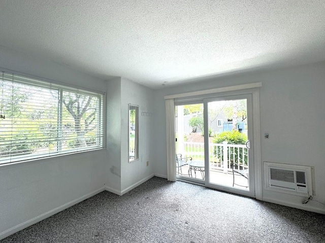 101 Fletcher Unit K, Brewster, MA 02631 - carpeted empty room featuring a textured ceiling, a wall unit AC, and baseboards