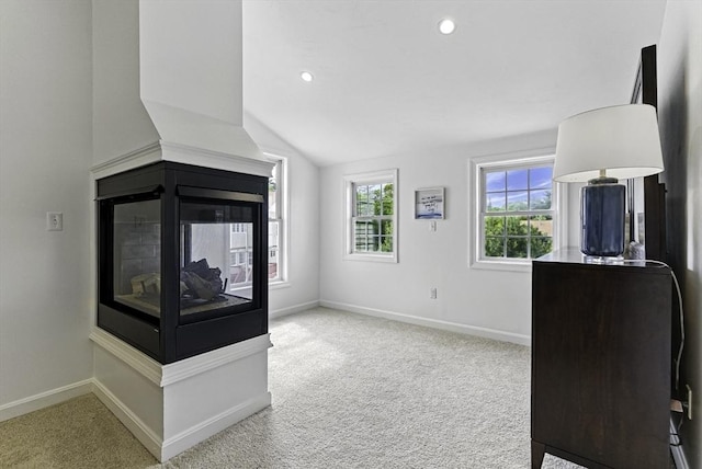 12 Paul Revere Path Unit 12, Hopkinton, MA 01748 - unfurnished living room featuring carpet, lofted ceiling, baseboards, recessed lighting, and a multi sided fireplace