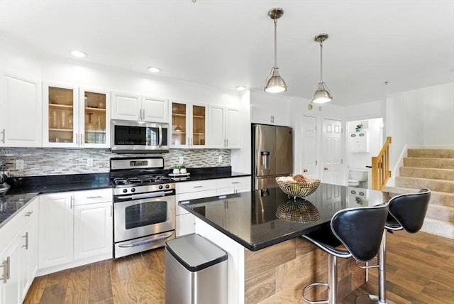 12 Paul Revere Path Unit 12, Hopkinton, MA 01748 - kitchen with appliances with stainless steel finishes, a kitchen breakfast bar, dark countertops, dark wood-style floors, and recessed lighting