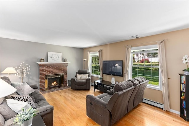 48 Logans Run, Attleboro, MA 02703 - living room featuring baseboard heating, light wood-style floors, and a brick fireplace