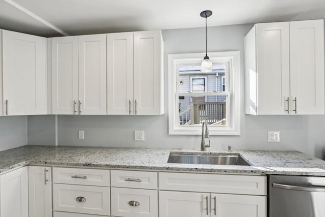 kitchen featuring sink, stainless steel dishwasher, white cabinets, and decorative light fixtures