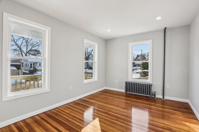 empty room with radiator and hardwood / wood-style flooring