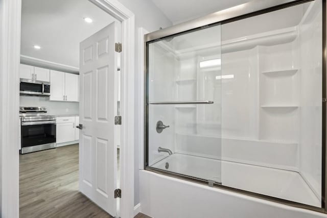 bathroom featuring bath / shower combo with glass door and hardwood / wood-style floors