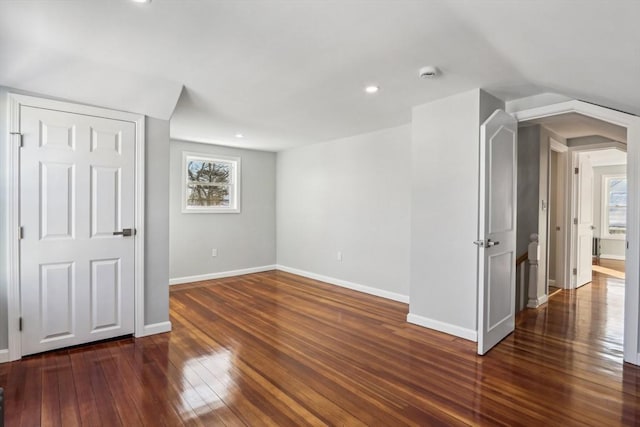 spare room featuring a wealth of natural light and dark wood-type flooring