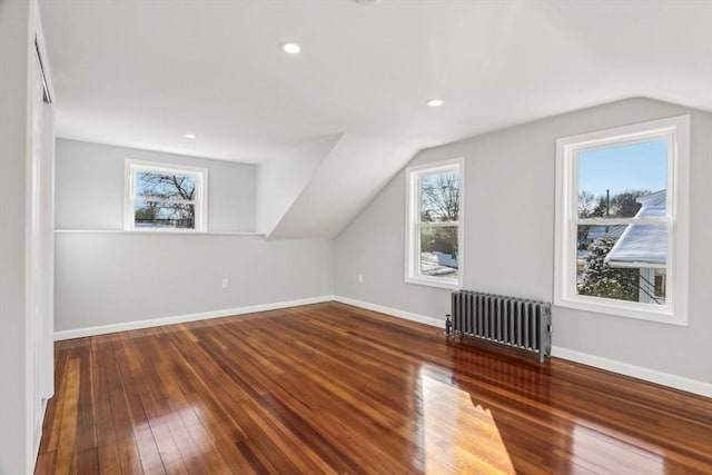 bonus room featuring hardwood / wood-style flooring, radiator, vaulted ceiling, and a wealth of natural light