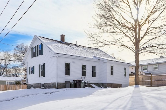 view of snow covered back of property