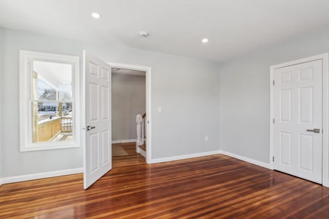 unfurnished bedroom with dark wood-type flooring