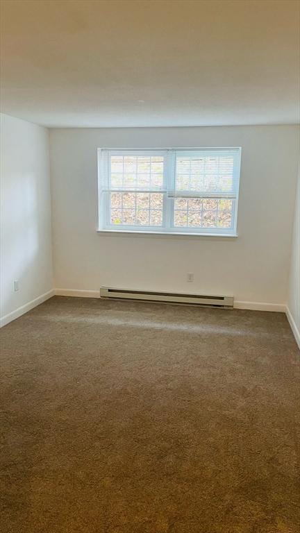 empty room featuring a baseboard radiator, dark carpet, and baseboards