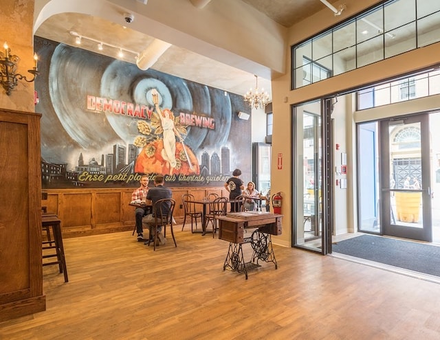 interior space featuring an inviting chandelier, rail lighting, a towering ceiling, and hardwood / wood-style floors