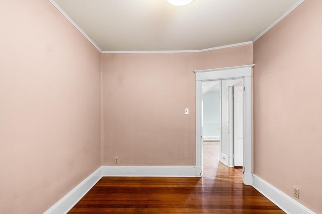 empty room with crown molding, hardwood / wood-style floors, and baseboard heating