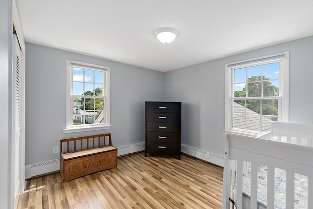 100 Elm St, Marshfield, MA 02050 - unfurnished bedroom with multiple windows, wood finished floors, a baseboard radiator, and baseboard heating