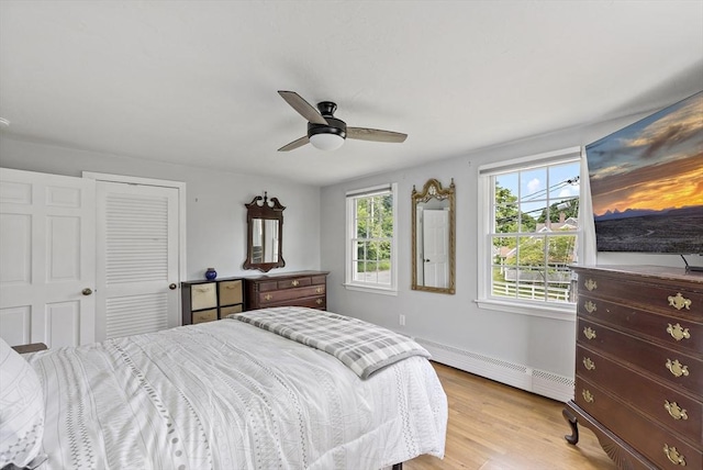 100 Elm St, Marshfield, MA 02050 - bedroom featuring a baseboard heating unit, light wood finished floors, a ceiling fan, and a closet