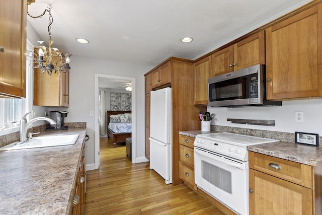 100 Elm St, Marshfield, MA 02050 - kitchen with white appliances, light wood-type flooring, brown cabinets, a chandelier, and recessed lighting