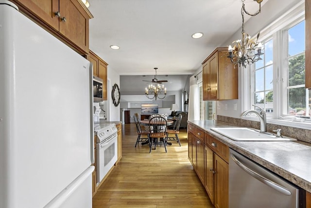 100 Elm St, Marshfield, MA 02050 - kitchen featuring white appliances, a chandelier, brown cabinetry, light wood-style floors, and pendant lighting