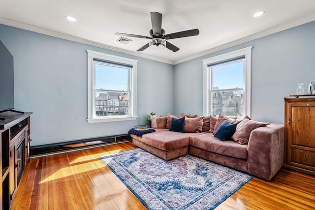 living room with plenty of natural light, hardwood / wood-style flooring, ceiling fan, and visible vents
