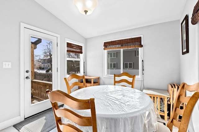 dining room with vaulted ceiling and baseboards