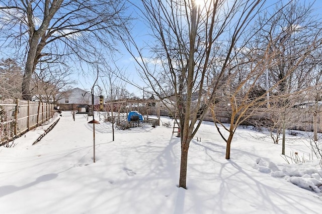 yard layered in snow featuring fence