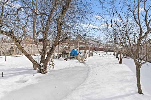 yard covered in snow featuring fence