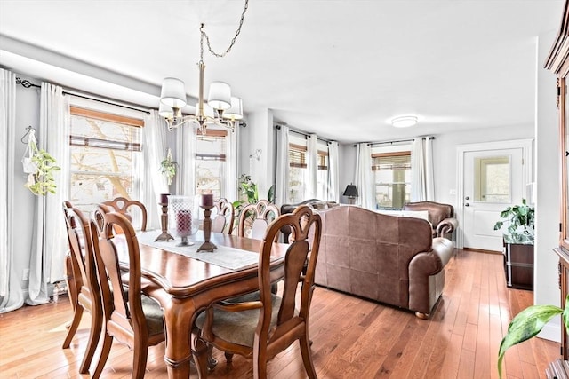 dining area featuring light wood-type flooring and an inviting chandelier