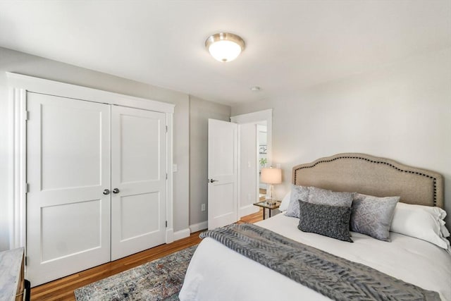 bedroom with a closet, baseboards, and wood finished floors