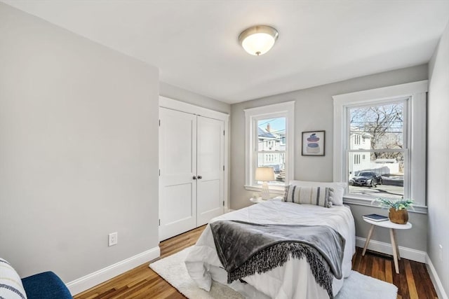 bedroom featuring a closet, baseboards, and wood finished floors