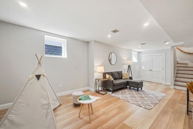 living room with light wood finished floors, visible vents, stairs, a healthy amount of sunlight, and recessed lighting