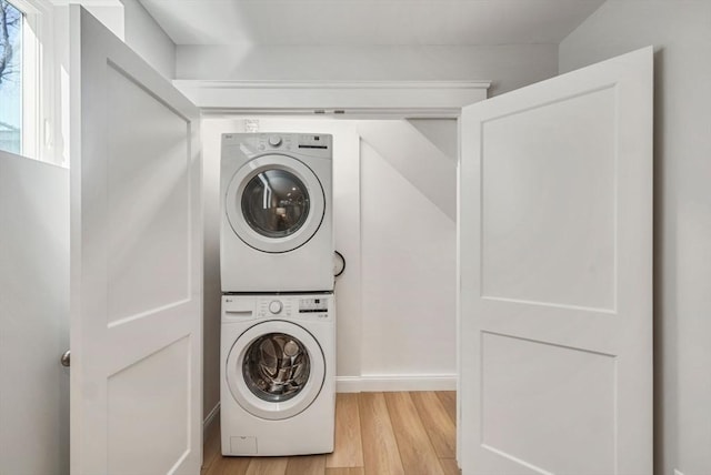 washroom with laundry area, stacked washing maching and dryer, and light wood-style flooring