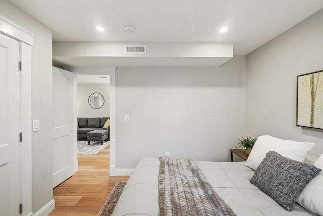 bedroom featuring light wood-type flooring, baseboards, visible vents, and recessed lighting