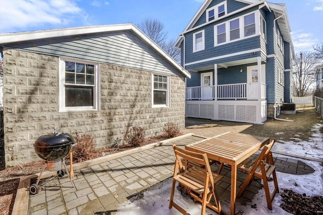 back of house featuring central air condition unit, a porch, and a patio