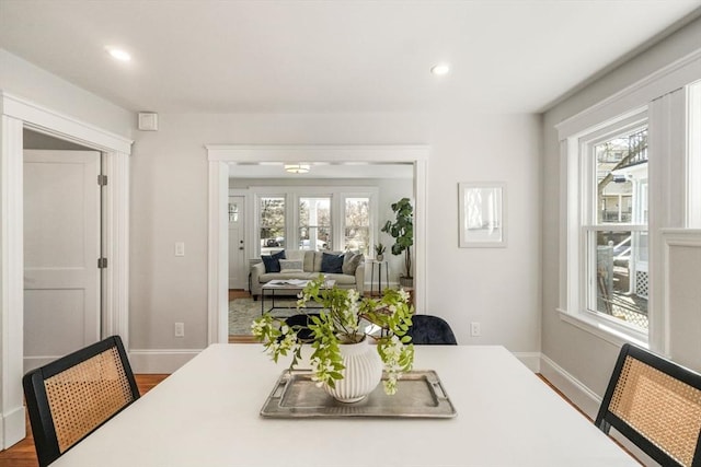 dining space featuring baseboards, wood finished floors, and recessed lighting